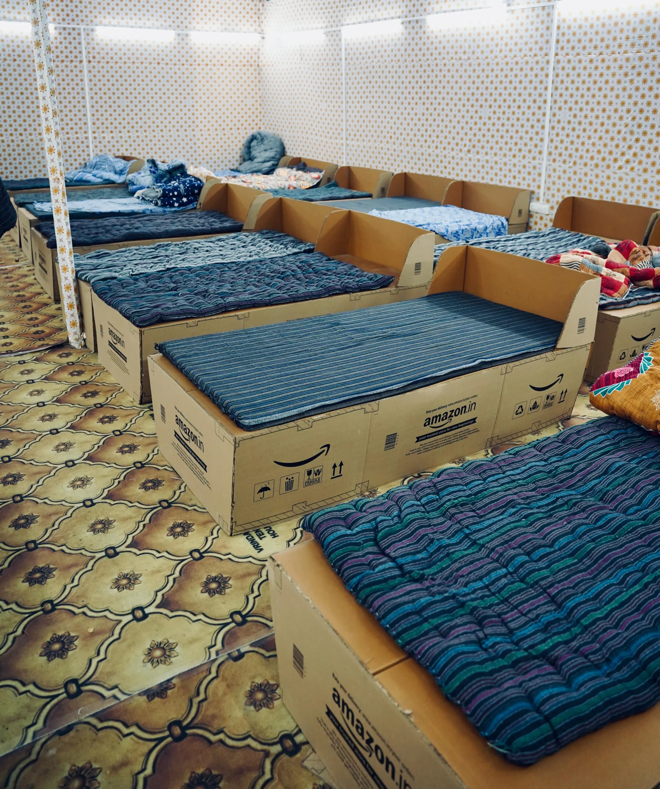 Amazon India, Maha Kumbh Mela 2025, upcycled beds, cardboard box beds, sustainable innovation, social impact, Prayagraj, festival accommodation, Amazon packaging, Ogilvy India, Kumbh Mela initiative, community support, lost and found center, Kumbh Police, Kumbh hospital, pilgrimage support, corporate social responsibility, eco-friendly initiative, public welfare, festival comfort, innovative solutions, repurposed materials, Amazon corporate initiatives, sustainable festival solutions, large-scale religious gatherings, Maha Kumbh social initiatives, Amazon India community projects, smart packaging reuse, festival infrastructure, environmental responsibility, green initiatives, Maha Kumbh public service, social responsibility in business, 