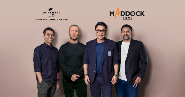 Universal Music India and Maddock Films executives shaking hands, announcing their strategic partnership for Hindi film music and upcoming soundtracks