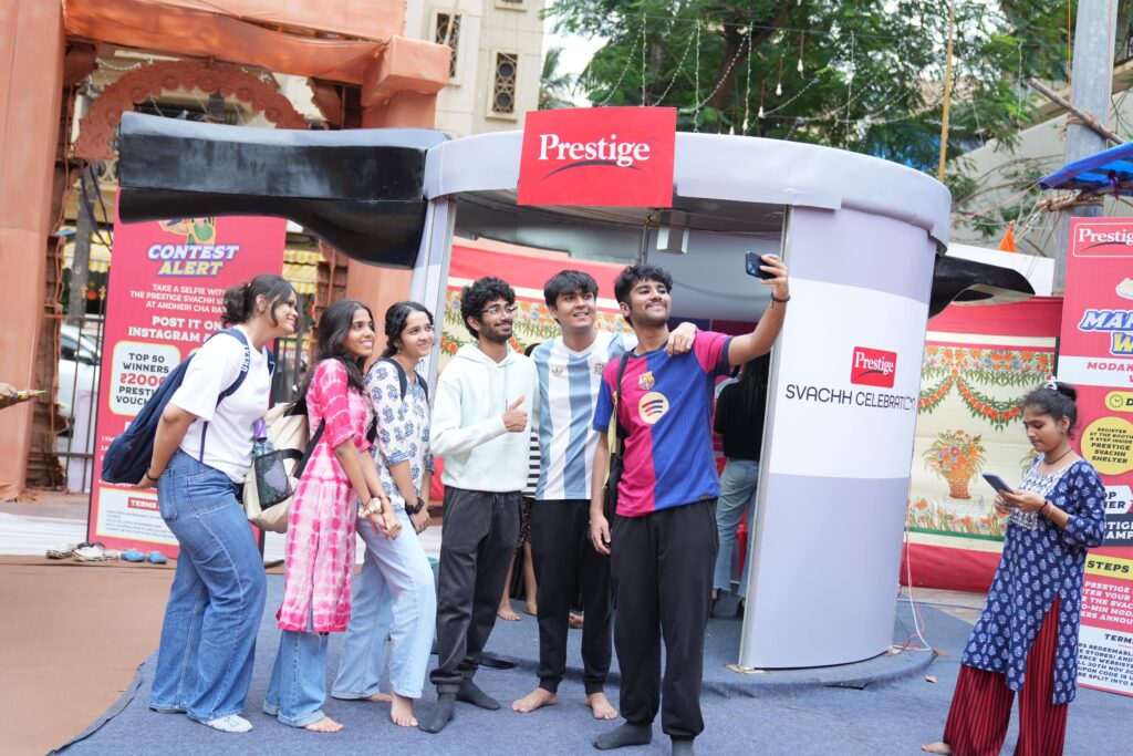 Visitors engage with TTK Prestige Svachh Shelter at Andhericha Raja during Ganesh Chaturthi 2025, taking selfies, participating in modak-making challenges, and pledging for clean kitchens and mindful water use